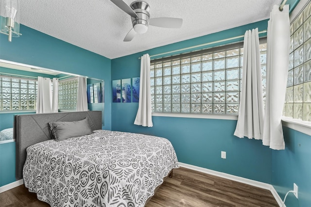 bedroom featuring ceiling fan, wood-type flooring, and multiple windows