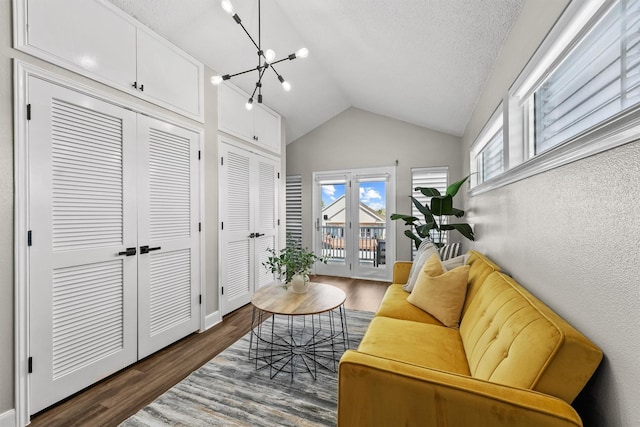 living room featuring dark hardwood / wood-style flooring, an inviting chandelier, and vaulted ceiling