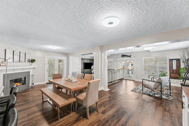 dining space featuring dark wood-type flooring, a textured ceiling, and french doors