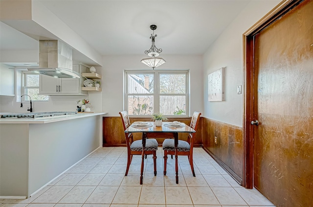 tiled dining room featuring wooden walls