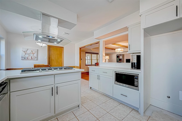 kitchen featuring white cabinets, island exhaust hood, light tile patterned floors, and stainless steel appliances