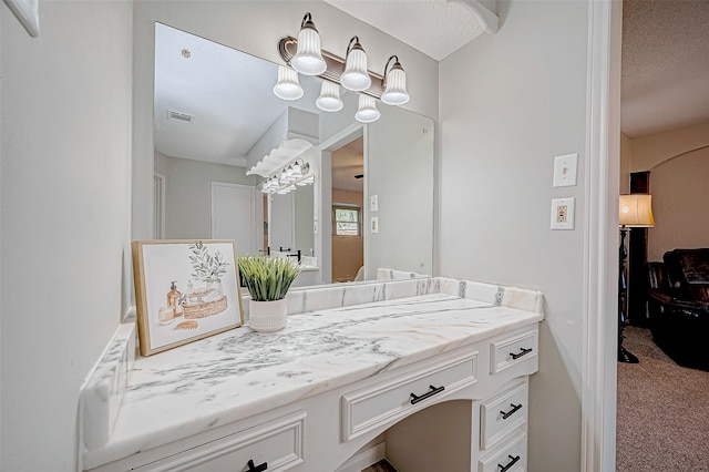 bathroom with a textured ceiling and vanity