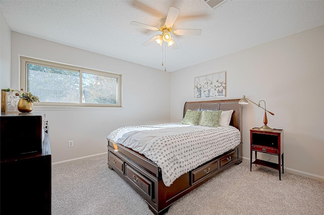 bedroom featuring ceiling fan, light colored carpet, and a textured ceiling