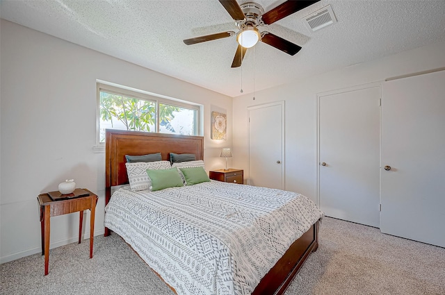 carpeted bedroom with a textured ceiling and ceiling fan