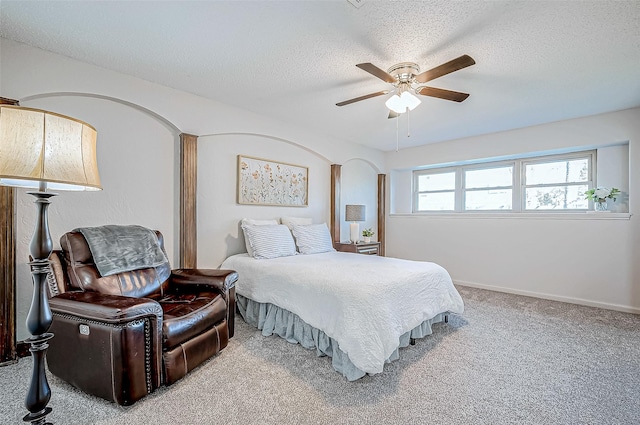 carpeted bedroom featuring ceiling fan and a textured ceiling