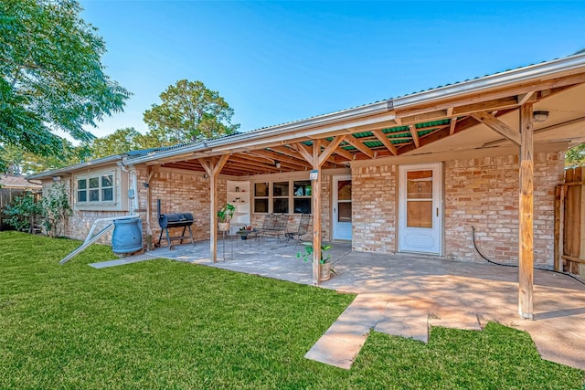 back of house featuring a lawn and a patio