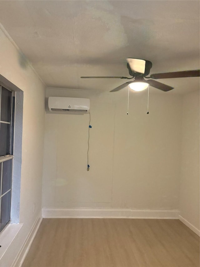 unfurnished room featuring a wall mounted AC and wood-type flooring