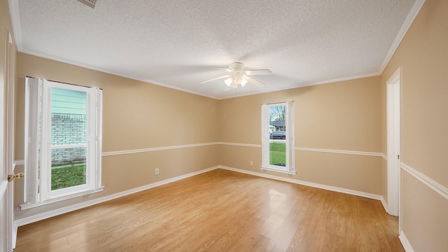 unfurnished room with crown molding, light wood-type flooring, and a textured ceiling