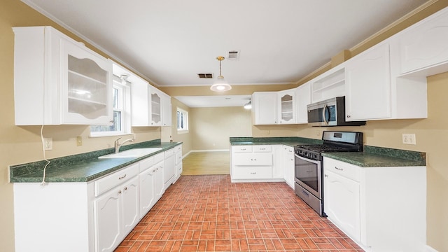 kitchen featuring appliances with stainless steel finishes, ornamental molding, sink, white cabinetry, and hanging light fixtures