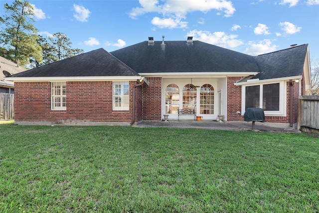 back of property featuring fence, a patio, and a yard