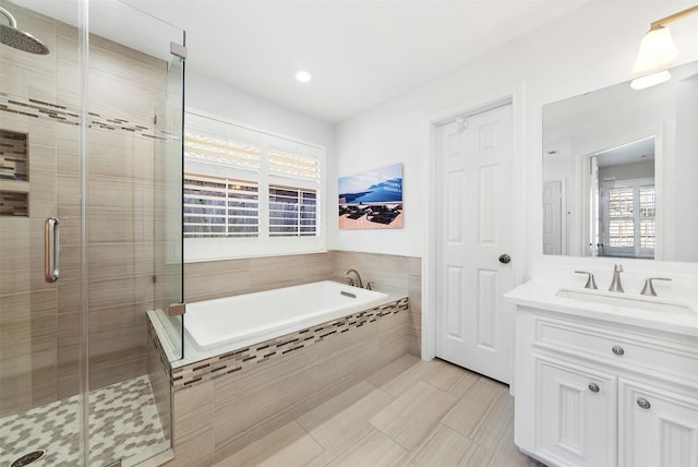 full bath with a garden tub, vanity, and a shower stall