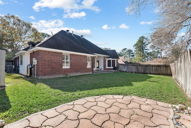 rear view of house featuring a yard and central AC