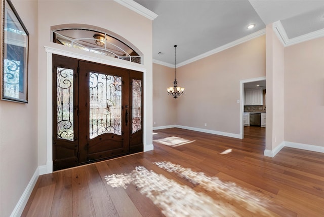 entryway featuring hardwood / wood-style floors, ornamental molding, and a chandelier