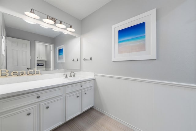 bathroom featuring wainscoting, wood finished floors, and vanity