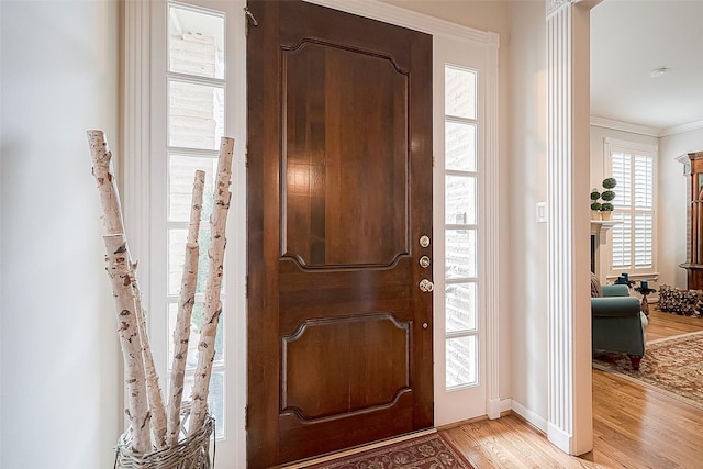 foyer featuring crown molding and light wood-type flooring