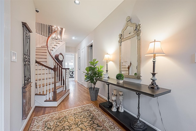 foyer featuring wood-type flooring and an inviting chandelier