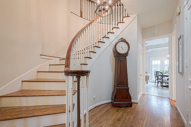 stairway featuring a notable chandelier and hardwood / wood-style flooring