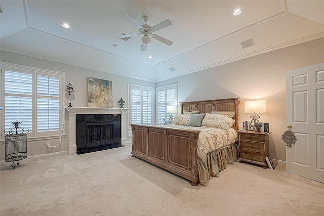 bedroom featuring a tile fireplace, crown molding, vaulted ceiling, ceiling fan, and light colored carpet