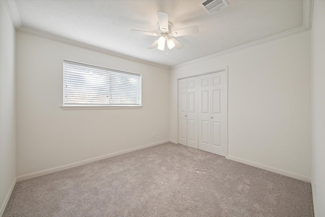 unfurnished bedroom featuring light carpet, a closet, ceiling fan, and crown molding