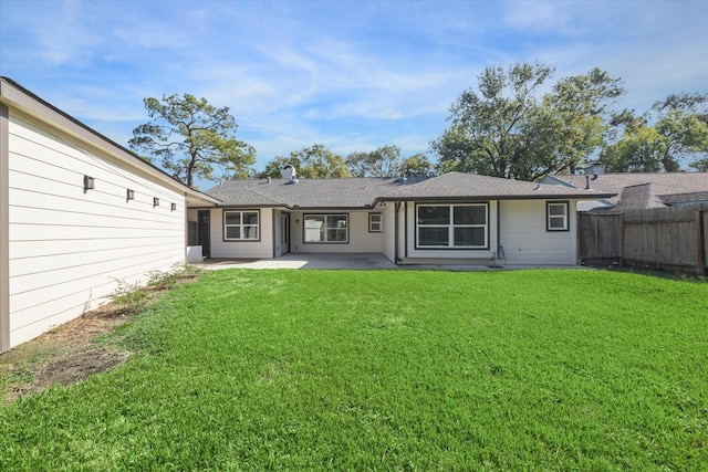 rear view of property with a patio and a lawn