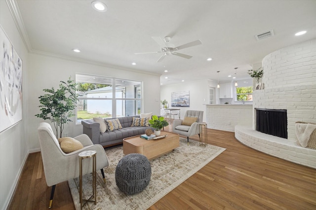 living room with hardwood / wood-style floors, ceiling fan, a fireplace, and a healthy amount of sunlight