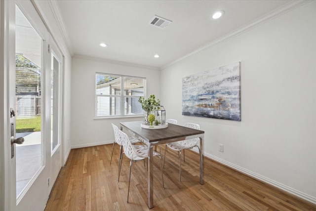 dining area with wood-type flooring and ornamental molding