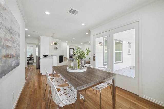 dining area with wood-type flooring and crown molding