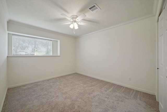 carpeted spare room featuring ceiling fan and ornamental molding