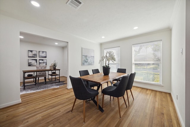 dining area featuring light hardwood / wood-style floors and ornamental molding