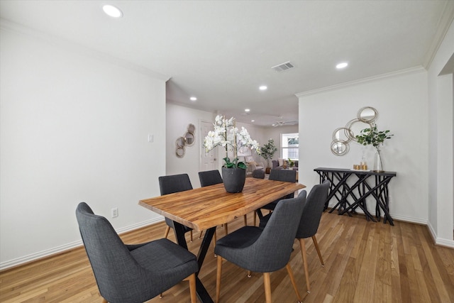 dining room featuring light hardwood / wood-style flooring and crown molding