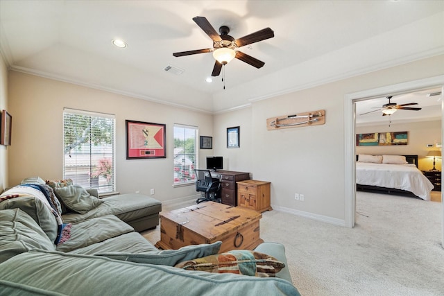 living room with a tray ceiling, light carpet, crown molding, and ceiling fan