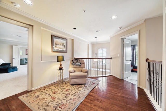 living area featuring a notable chandelier, ornamental molding, and dark wood-type flooring