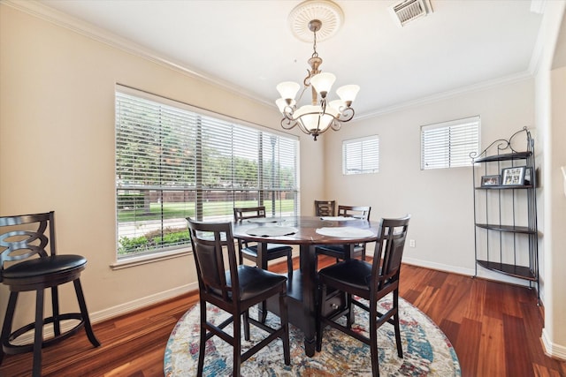 dining space featuring dark hardwood / wood-style floors, an inviting chandelier, and ornamental molding