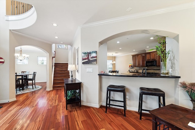 kitchen with a breakfast bar, kitchen peninsula, hanging light fixtures, and a healthy amount of sunlight