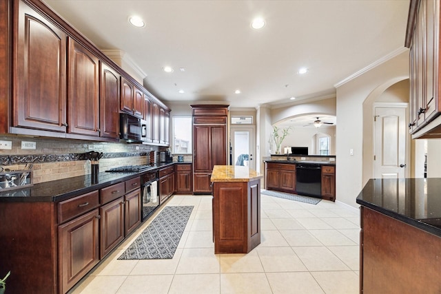 kitchen featuring a center island, black appliances, dark stone countertops, ornamental molding, and light tile patterned floors