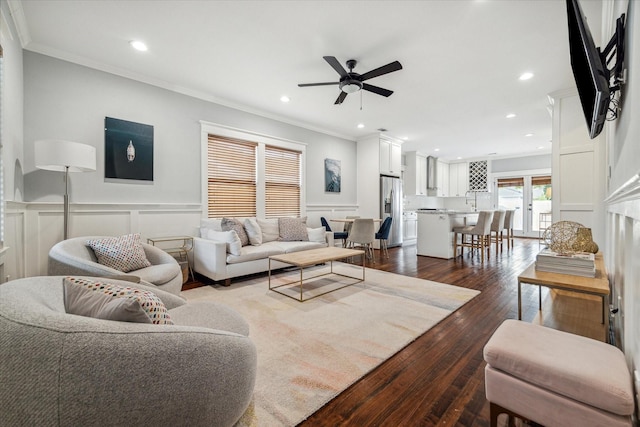 living room featuring ceiling fan, dark wood-type flooring, and ornamental molding