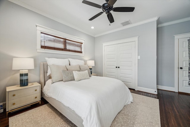 bedroom with dark wood-type flooring, ceiling fan, crown molding, and a closet