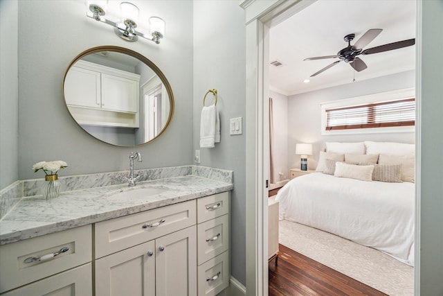 bathroom featuring wood-type flooring, vanity, ceiling fan, and ornamental molding