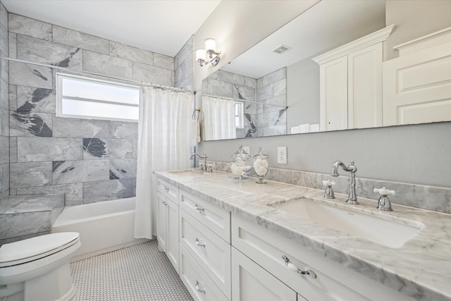 full bathroom featuring tile patterned floors, shower / bath combo with shower curtain, vanity, and toilet