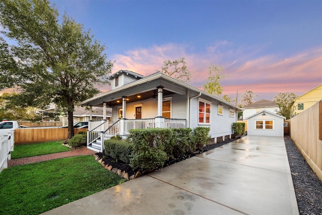 view of front of property with a porch, an outbuilding, a lawn, and a garage