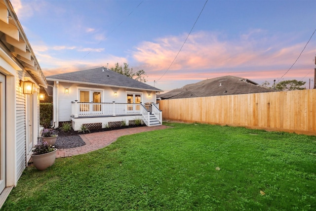 yard at dusk featuring a wooden deck