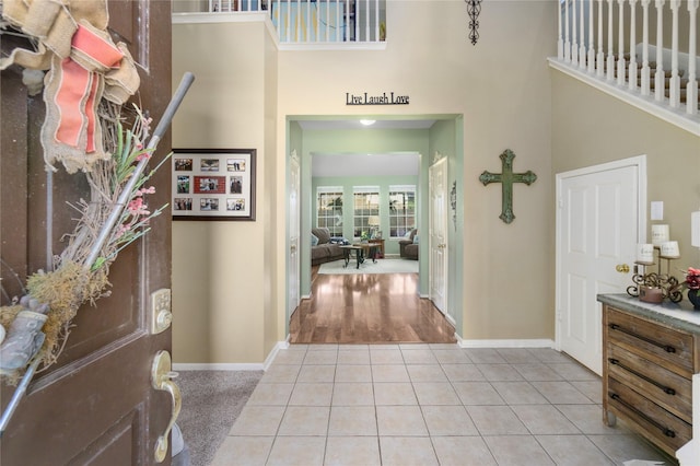 tiled entrance foyer featuring a towering ceiling