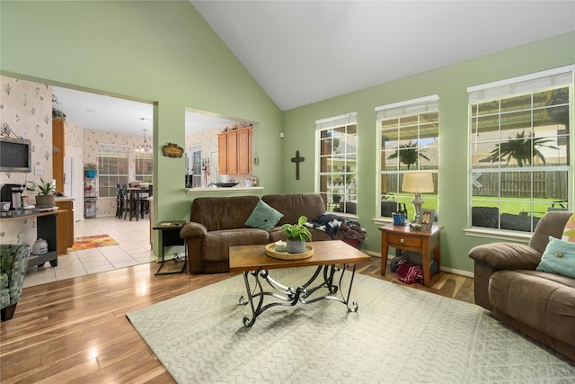 living room with light wood-type flooring and high vaulted ceiling