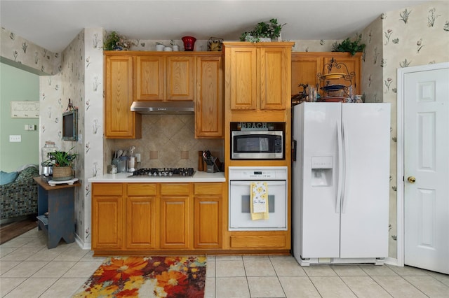 kitchen featuring backsplash, light tile patterned floors, and stainless steel appliances