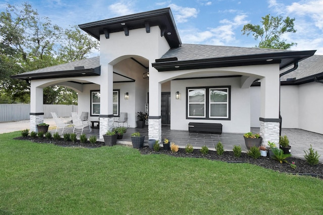 view of front of house featuring a porch, a patio, and a front lawn