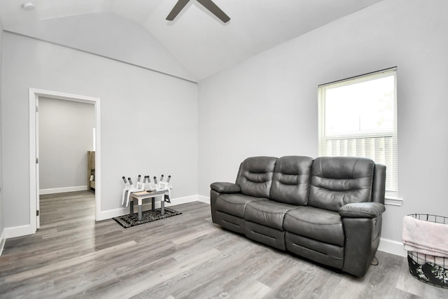 living room featuring ceiling fan, wood-type flooring, and vaulted ceiling