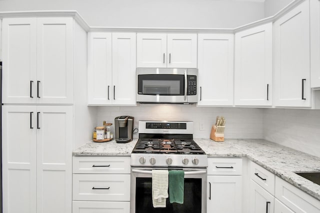 kitchen featuring tasteful backsplash, white cabinetry, and appliances with stainless steel finishes