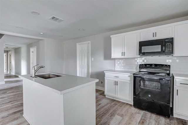 kitchen with backsplash, black appliances, white cabinets, sink, and an island with sink