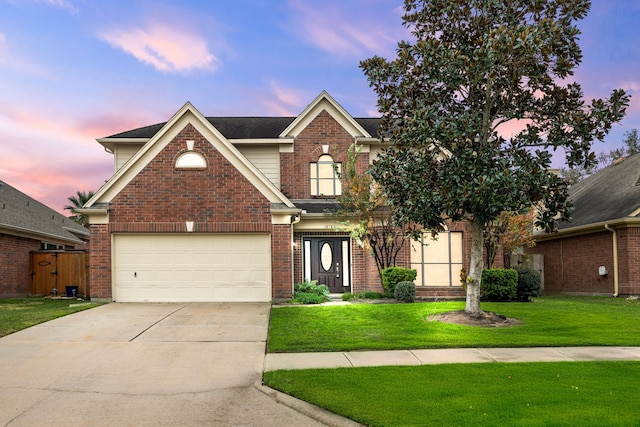 front of property with a garage and a lawn