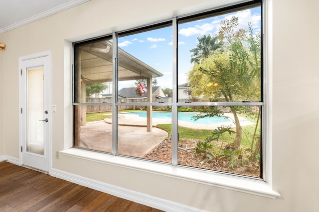 doorway to outside featuring hardwood / wood-style floors and crown molding